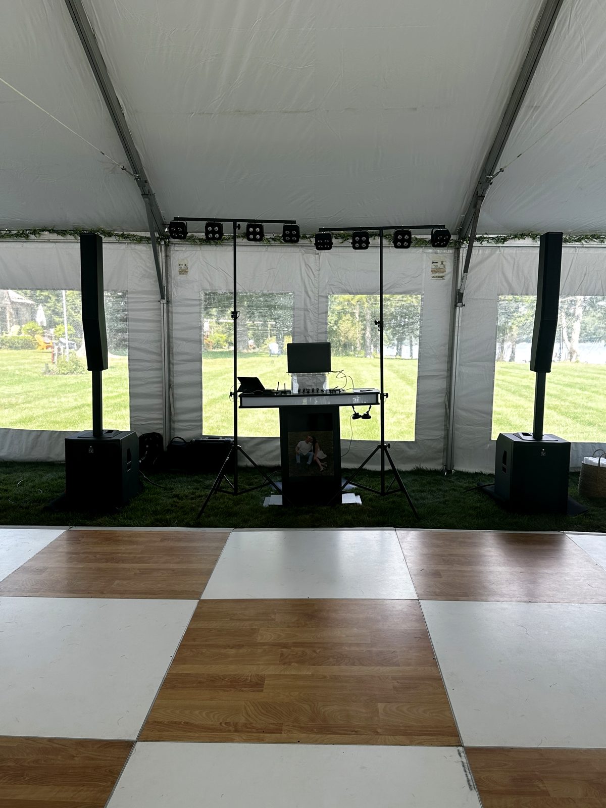 Tented outdoor wedding setup with a checkered dance floor